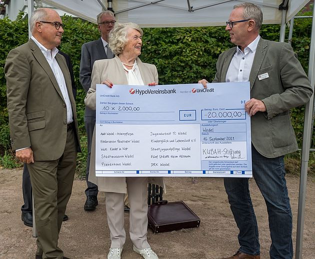 Karin Brennecke-Barnekow übergab einen symbolischen Scheck an Bürgermeister Niels Schmidt (rechts), mit dem die KUBAH-Stiftung zehn Wedeler Einrichtungen mit jeweils 2.000 Euro unterstützt. Foto: Stadt Wedel/Kamin 