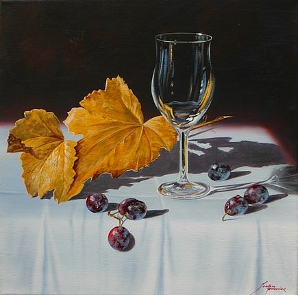 Ein Weinglas mit herbstlichen Weinblättern und Weintrauben