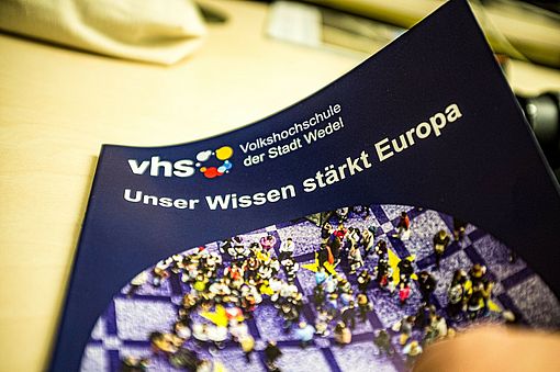 Seit dem 4. Januar 2024 ist das Frühjahrsprogramm der Volkshochschule Wedel mit dem Motto „Unser Wissen stärkt Europa“ als Heft oder online erhältlich. Foto: Stadt Wedel/Kamin
