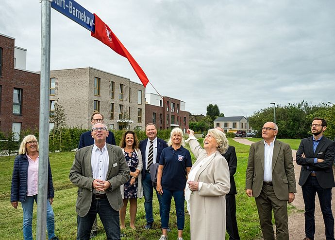 Karin Brennecke-Barnekow enthüllte im Beisein vieler Gäste das neue Schild des Kurt-Barnekow-Weges. Foto: Stadt Wedel/Kamin