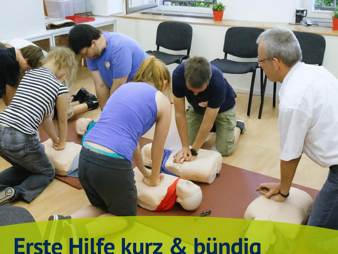 Teilnehmende des Kurses "Erste Hilfe kurz & bündig" sitzen um eine Puppe und üben die Herzdruckmassage