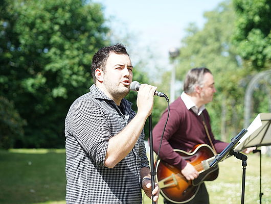 Nathan Elcox am Mikrofon und Martin Ulleweit (Gitarre) bei einem Konzert der Musikschule für die Bewohner der Kursana Residenz