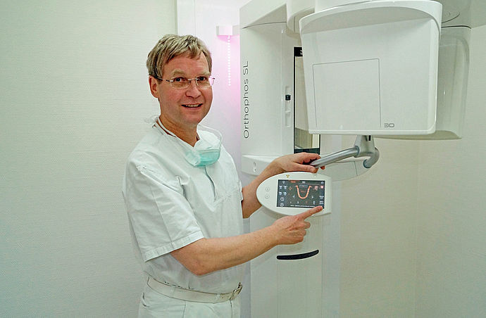 Dr.Wulf Wentorp steht neben einem Digitalen-Volumen-Tomogramm-Gerät.