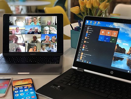 Personen beim Online-Meeting winken in die Kamera