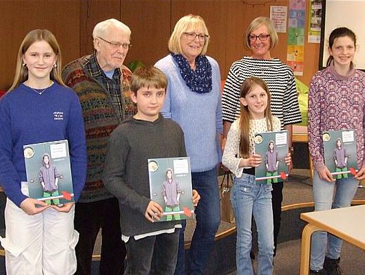 Bild 1: Die vier Wettbewerbs-Teilnehmer*innen Juli, Theo, Emma und Pia (von links) nach der Urkundenvergabe mit den Jurymitgliedern H. Ihlenfeld, R. Steinbach und S. Foßhag (von links) (Foto: Stadtbücherei)