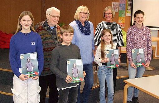 Bild 1: Die vier Wettbewerbs-Teilnehmer*innen Juli, Theo, Emma und Pia (von links) nach der Urkundenvergabe mit den Jurymitgliedern H. Ihlenfeld, R. Steinbach und S. Foßhag (von links) (Foto: Stadtbücherei)