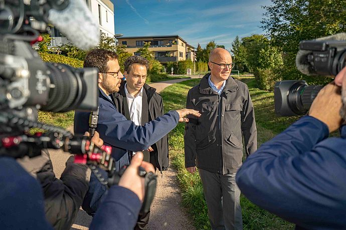 Der Leiter der Wedeler Stadtentwässerung, Christopher Seydewitz (von links) erklärte dem 3. Stv. Bürgermeister der Stadt Wedel Tobias Kiwitt und dem Schleswig-Holsteinischen Umweltminister Tobias Goldschmidt, die Funktionsweise der Regenwasseranlage am Kurt-Barnekow-Weg. Foto: Stadt Wedel/Kamin