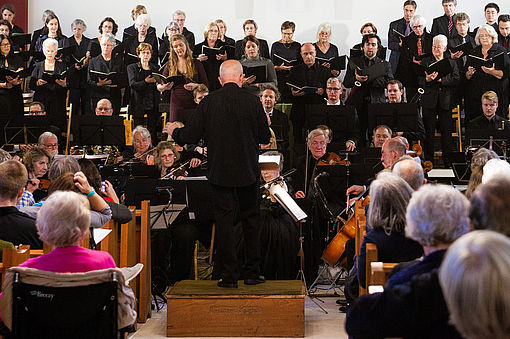 Das Bild zeigt Chor und Solisten in der vollbesetzten Kirche