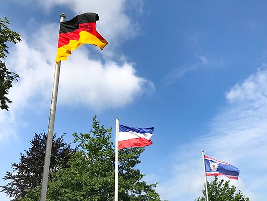 Auf dem Bild befinden sich die Flaggen von Deutschland, Schleswig-Holstein und Wedel