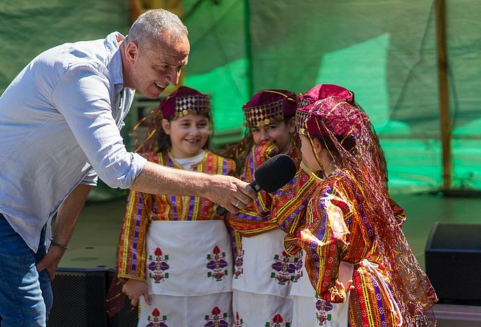 Im Interview: Rainer Bleuel und die Tänzerinnen der Tanzgruppe des Türkischen Elternbundes Wedel. Foto: Stadt Wedel/Kamin