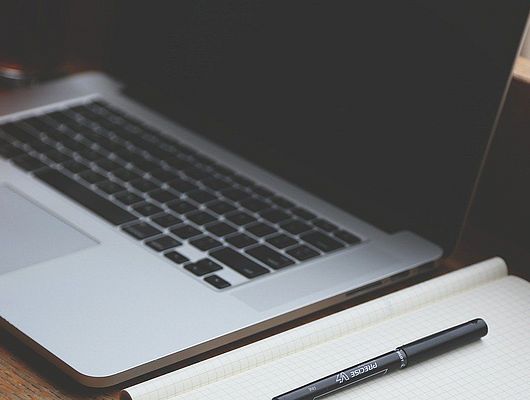 Arbeitsplatz mit einem Laptop und Schreibblock