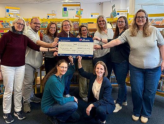 Das Team der Stadtbücherei um Büchereileiterin Ilka Hachenberg (vorne rechts) freut sich über den symbolischen 2.000 Euro Scheck von "VLH hilft" (Foto: Stadtbücherei)
