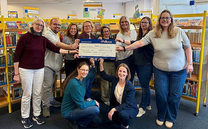 Das Team der Stadtbücherei um Büchereileiterin Ilka Hachenberg (vorne rechts) freut sich über den symbolischen 2.000 Euro Scheck von "VLH hilft" (Foto: Stadtbücherei)