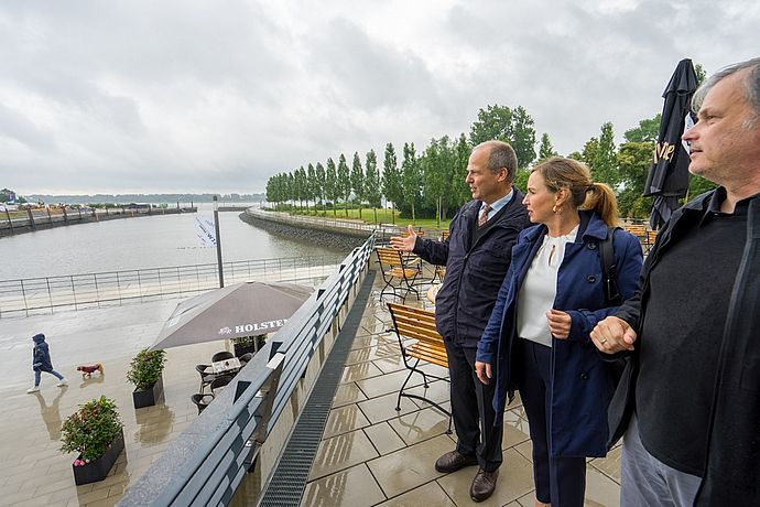 Minister Werner Schwarz, Wedels 2. Stv. Bürgermeisterin Julia Fisauli und Architekt Ole Flemming (v.l.) blickten von der Terrasse des "Hotel Hafen Wedel" über das gesamte Areal. Foto: Stadt Wedel/Kamin  