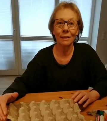 Marita mit einem Eierkarton aus dem sie ein Spiel bastelt