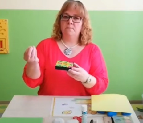 Nina vor einem Tisch mit dem Bastelmaterial für ein Tic-Tac-Toe-Spiel