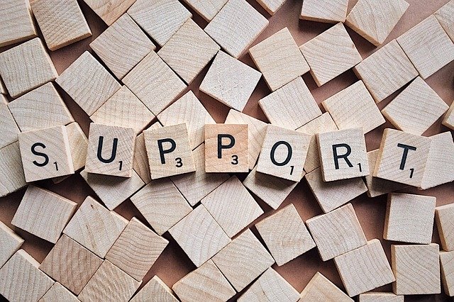 Buchstaben  auf kleinen Holzplättchen des Spiels Scrabble formen das Wort Support